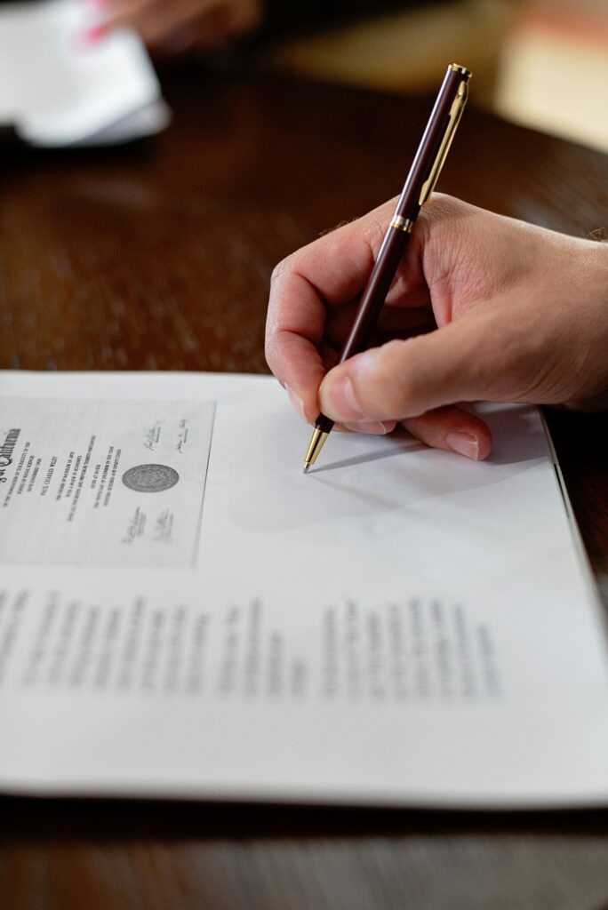 Restoring Fiscal Health: Proven Strategies for Municipal Recovery A detailed close-up photo of a hand signing a formal document with a pen, creating a professional agreement.